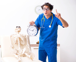 Funny doctor with skeleton in hospital