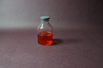 pequeñas botellas de vidrio con tapon gris con liquido de color rojo