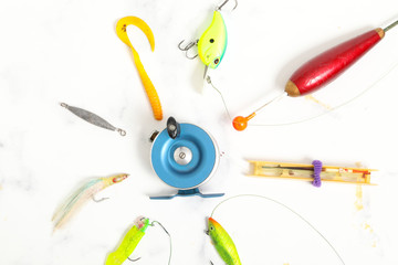many fishing equipement on white marble background