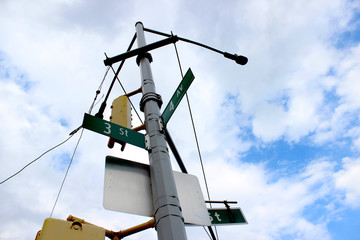 A light pole with a traffic light and the designation 3 streets and 4 streets in new York