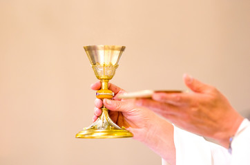 chalice with wine, blood of christ, and pyx with bread, body of christ, ready for the communion of...