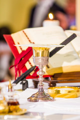 altar with missal and host which becomes the body of Christ and chalice to receive the wine, the blood of Christ
