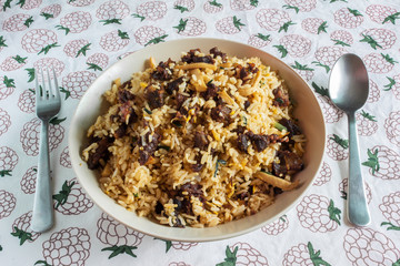 A plate of fried rice with beef and mushroom served on a table in a restaurant