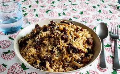 A plate of fried rice with beef and mushroom served on a table in a restaurant
