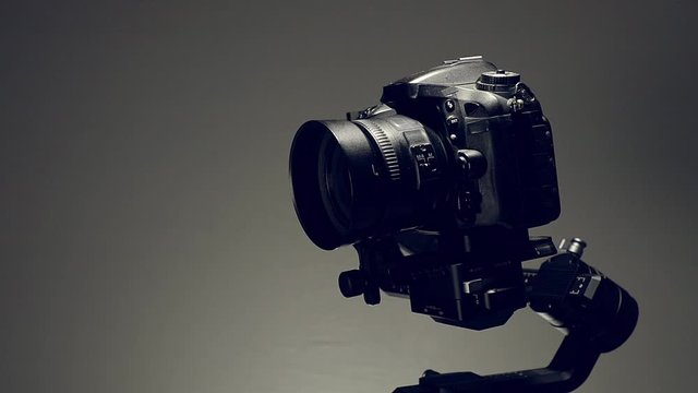 Estabilizador o Gimbal con una camara montada, haciendo movimientos de grabacion con fondo de color