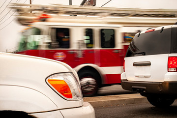 Fire truck blurred as it passes cars in foregound stopped traffic