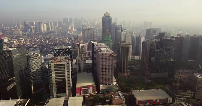 Straight aerial flight towards metropolitan city's high rise buildings. Drone, 4K.