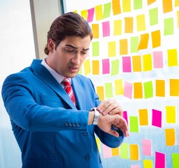 Young handsome employee with many conflicting priorities