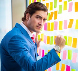 Young handsome employee with many conflicting priorities