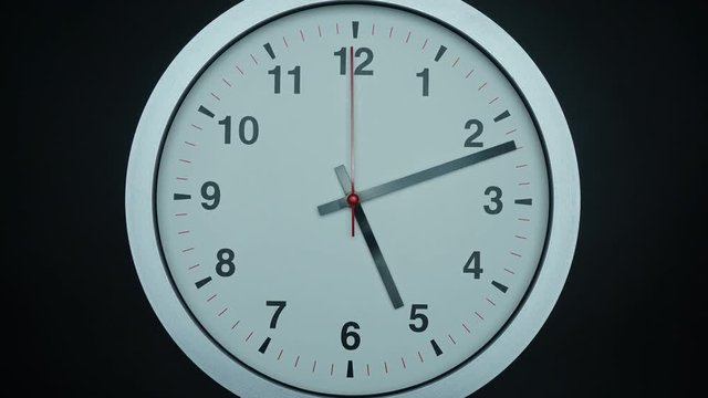Gray wall clock isolated face beginning of time 05.00 am or pm. on black background, Time lapse 60 minutes moving fast, Time concept.