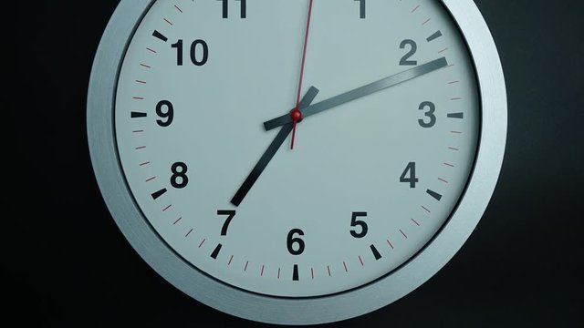 Close up Angle camera from bottom to top, Gray wall clock 7 o'clock on black background, Time lapse 60 minutes moving fast, Time concept.