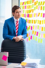 Young handsome employee with many conflicting priorities