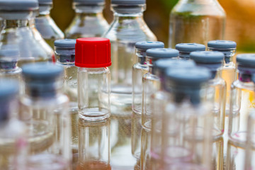 pequeña botella de vidrio transparente con tapa de color rojo junto con otras botellas pequeñas
