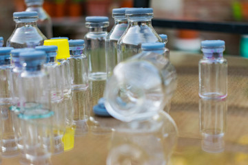 pequeñas botellas de vidrio de distintos colores y formas