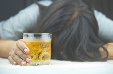 Glass of whiskey and background images in women headaches. The result of excessive alcohol consumption