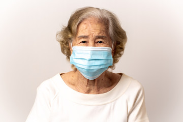 Close-up face of a old Asian woman wearing a mask