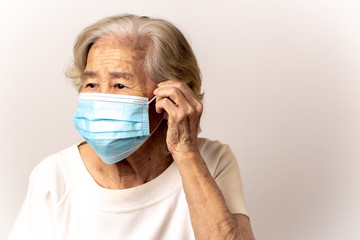 Close-up face of a old Asian woman wearing a mask