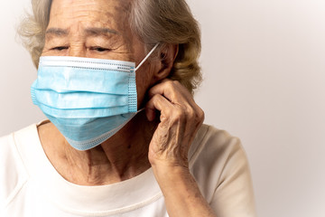 Close-up face of a old Asian woman wearing a mask