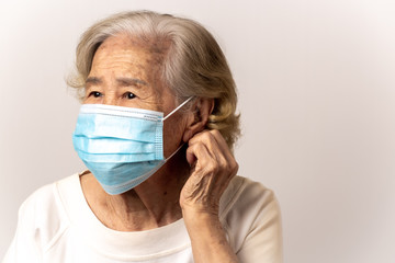 Close-up face of a old Asian woman wearing a mask