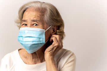 Close-up face of a old Asian woman wearing a mask