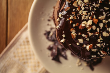 A view of delicious cocoa pancakes with dark chocolate and powdered sugar on a wooden table