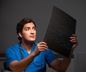 Young handsome doctor working night shift in hospital