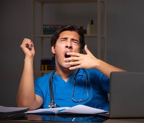 Young handsome doctor working night shift in hospital