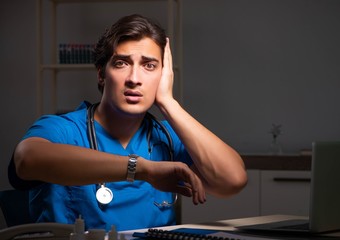 Young handsome doctor working night shift in hospital