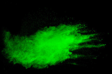 Green powder explosion on black background.Green dust particles splash.