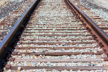 Railway track, rails, wooden sleepers, ballast stone gravel.