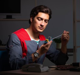 Young handsome repairman repairing computer