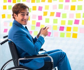Young handsome man in wheelchair with many conflicting prioritie