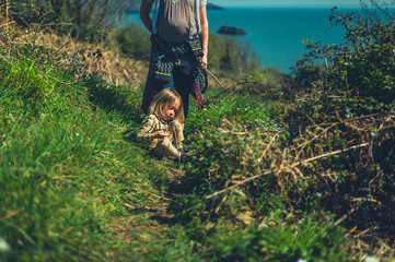 Mother and preschooler walking on hillside by the sea in spring