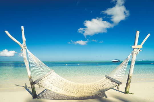 A hammock on the beach against a background of clouds, the ocean and an incredible sky