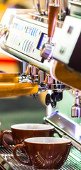 Espresso Machine pouring fresh coffee into cups at Local Coffee Shop.

