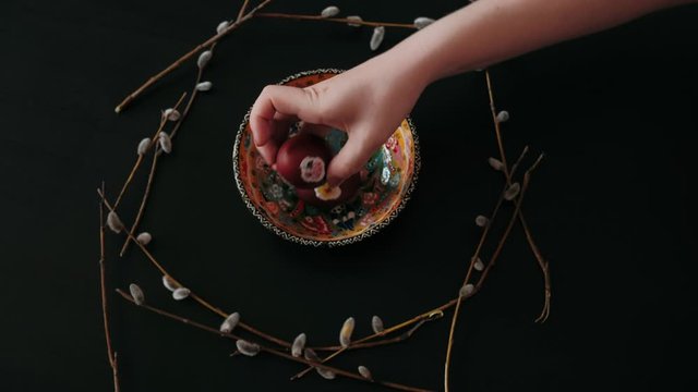 Easter eggs on a plate. Willow with seals. hands brut easter eggs