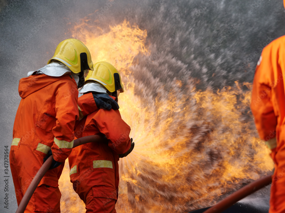 Poster firefighter spray water to fire burning car workshop fire training