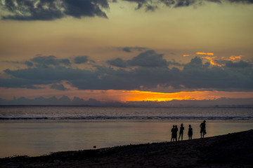 People walk on the ocean against the background of an incredible sunset. Mauritius, Indian Ocean.