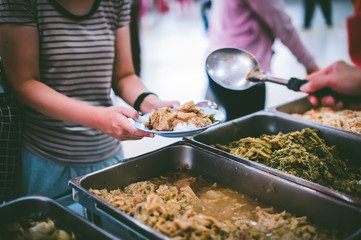 Volunteers serving food for poor people : concept of free food serving