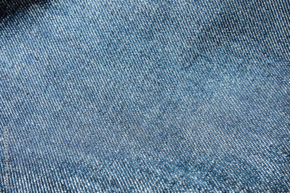 Wall mural Selective focus blue jean denim top view close up shot to the detail of fabric. textile material and cotton patter tough and durable garment style. For background or wallpaper with copy space for text