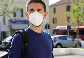 COVID-19 Pandemic Coronavirus Man in city street wearing KN95 FFP2 face mask protective for...