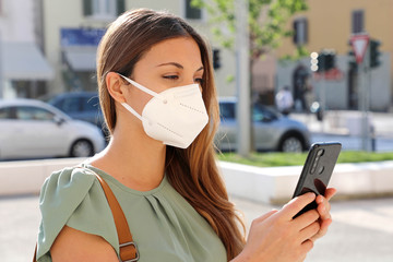 COVID-19 Mobile Application Young Woman Wearing KN95 FFP2 Mask Using Smart Phone App in City Street...