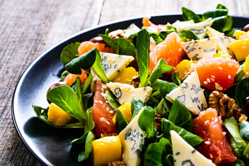 Fresh salad - blue cheese, fruit and vegetables on wooden table
