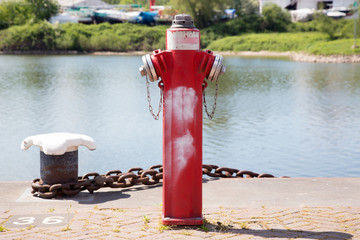 Bollard and red fire hydrant on the quay.