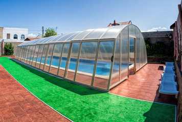 Covered summer pool with a blue tile. The covered area of the outdoor pool for hotel. Water retains...