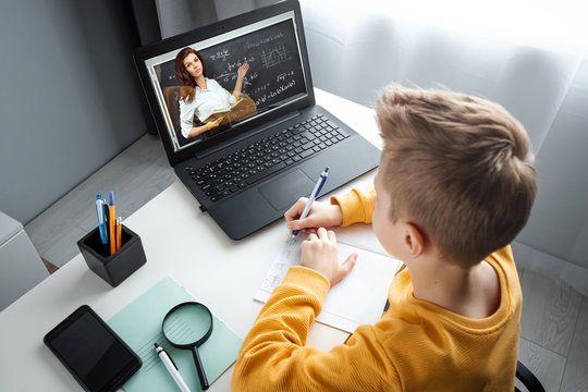 Distance learning, a boy learns math while looking at a laptop beech during an online lesson. The concept of online education, home education, technology, quarantine, self-isolation.