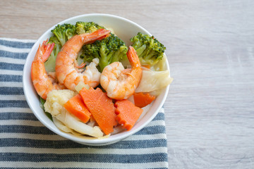 Top view of Homemade ​Stir Fried Mixed Vegetables with Shrimp, ​carrot, broccoli, on​ wooden​ background.​ Asian Healthy​ food​ for​ kid​ or for all family members.