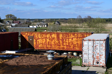 Photo of a shipping container against the backdrop of a landscape and blue sky in spring in clear weather. Universal concept.