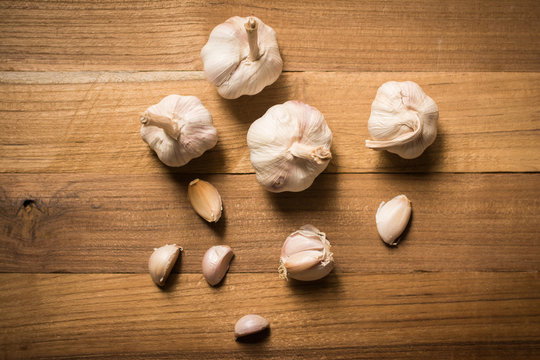 Garlic cloves and bulb in cloth vintage.
Garlic cloves on rustic table in wooden bowl. Fresh peeled garlic and bulbs.