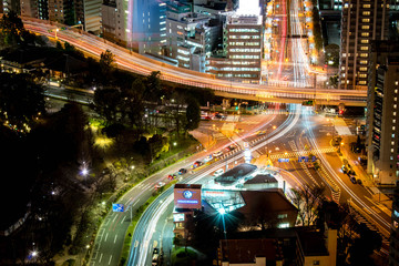 Night city roads with a lot of traffic and light trail – view from skyscrapers